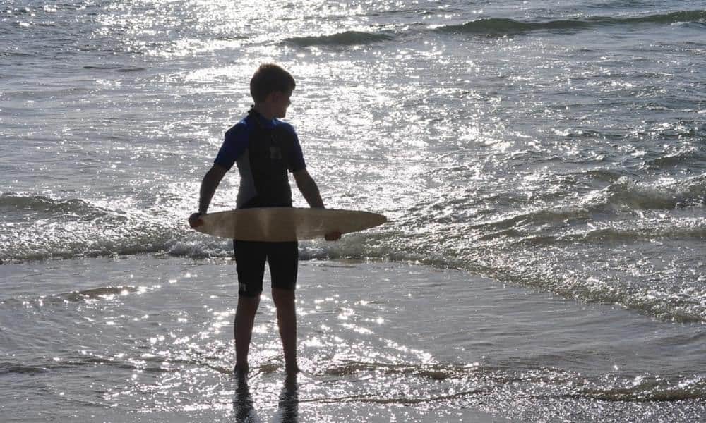 A child preparing to skimboard