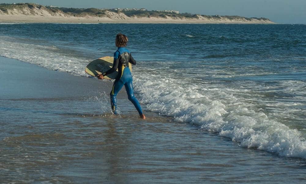A young boy skimboarding