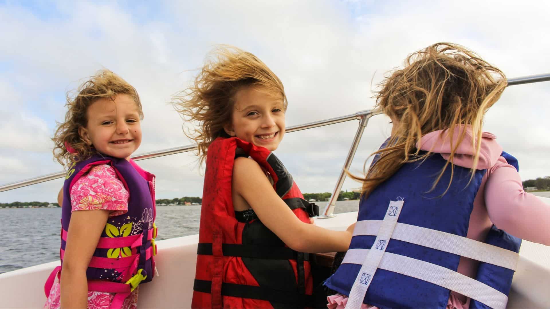 girls wearing pfd on a boat