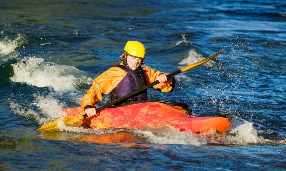 kayaker paddling in rapids