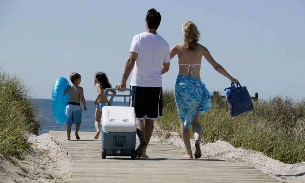 family carrying gear to the beach