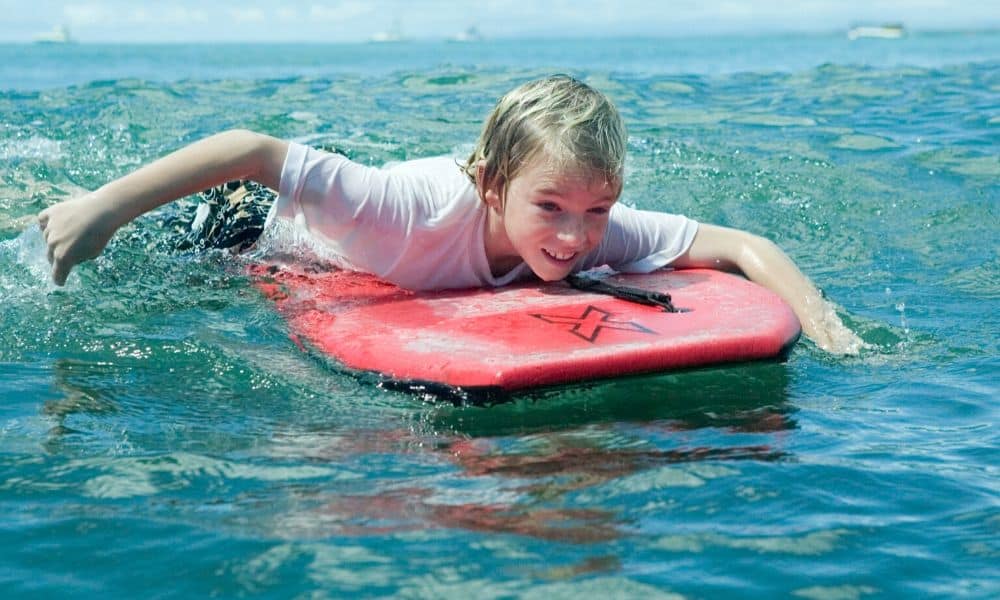 boy paddling a bodyboard