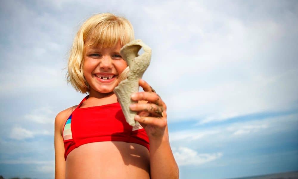 happy girl holding a seashell