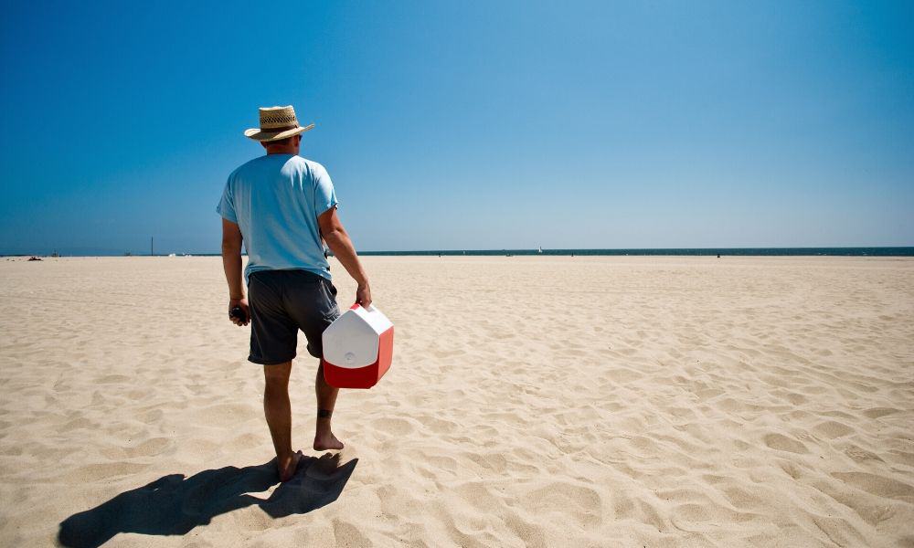 man carrying a beach cooler