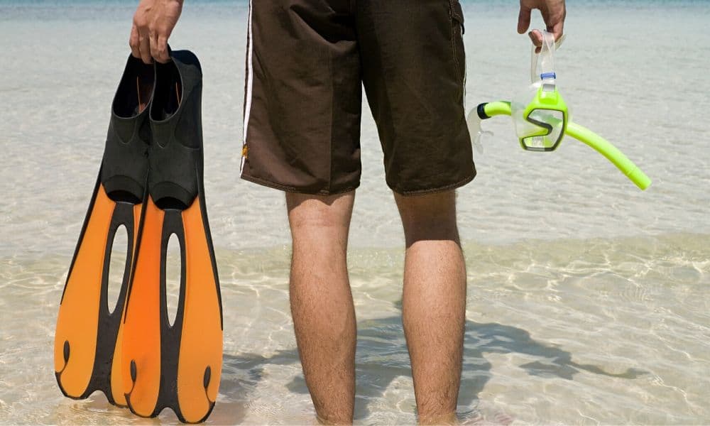 man carrying snorkeling fins