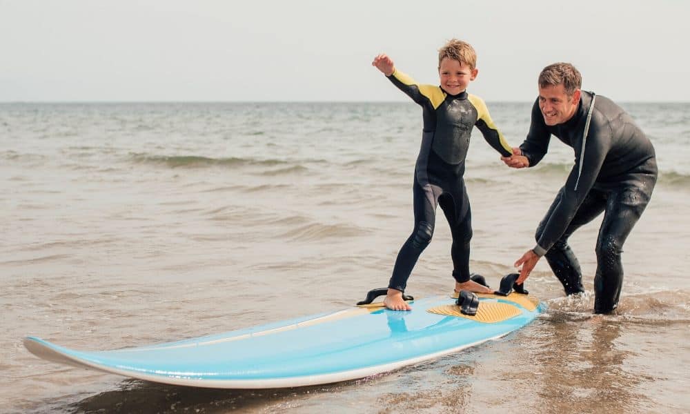 Dad teaching his son to surf